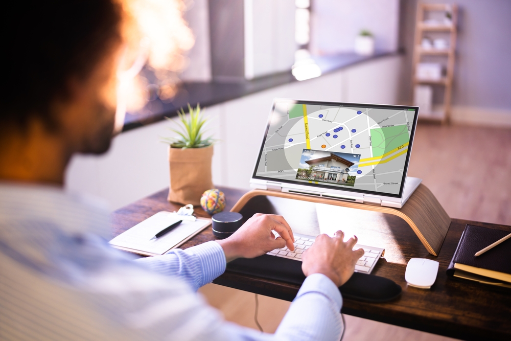 Person preparing to buy an investment property while reviewing listings on a computer.
